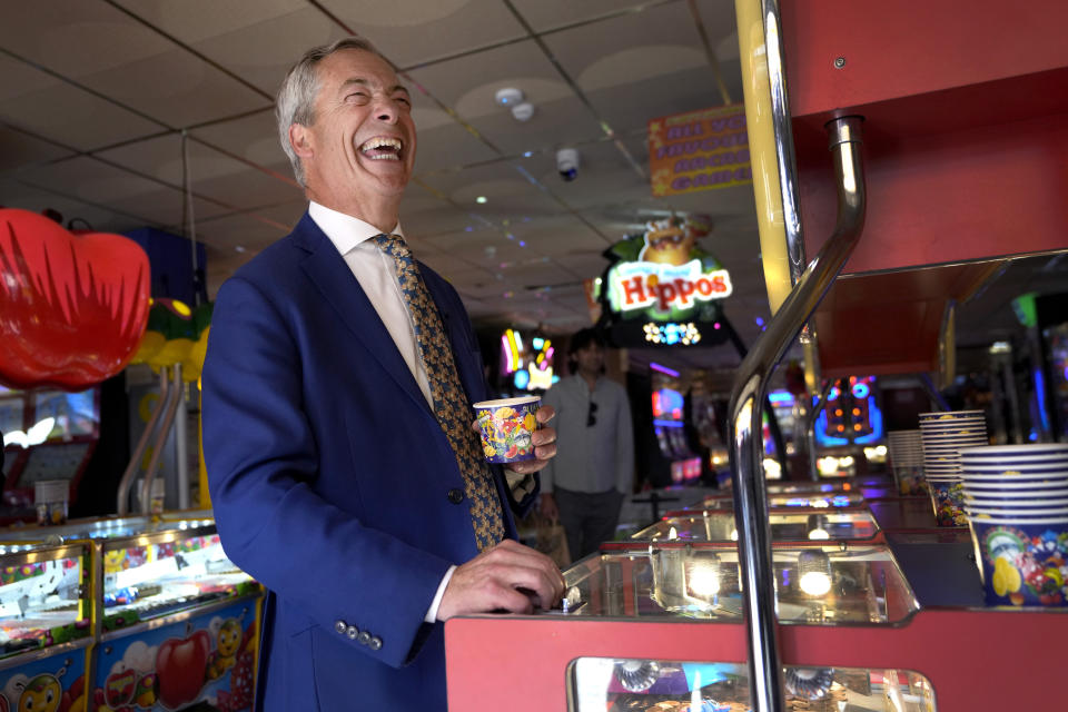 Reform UK party leader Nigel Farage plays a game in an amusement arcade in Clacton-On-Sea, England, Friday, June 21, 2024. Britain votes in a national election next week at a time of high public dissatisfaction over a host of issues. Many Conservative voters are turning away from the governing party, and some are switching to anti-immigration Reform. (AP Photo/Kirsty Wigglesworth)