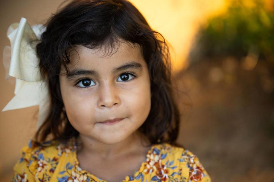 Four-year-old Madeline Gonzalez looks into the camera after a visit with her grandparents apartment in the Williams Migrant Center in July. Madeline is one of three generations at the migrant center who return to work in fields year after year from Mexico and other parts of the United States.