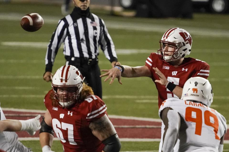 Wisconsin quarterback Graham Mertz throws a pass during the first half of an NCAA college football game against Illinois Friday, Oct. 23, 2020, in Madison, Wis. (AP Photo/Morry Gash)