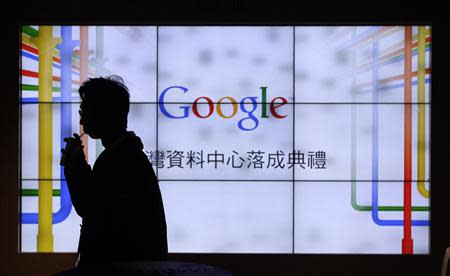 A man walks past a TV wall during a media tour at the Google data centre in Changhua Coastal Industrial Park, central Taiwan, December 11, 2013. Google Inc. said on Wednesday it will double its planned investment to $600 million for its data centre in Taiwan to cater to the world's fastest growing technology consumer markets. REUTERS/Pichi Chuang