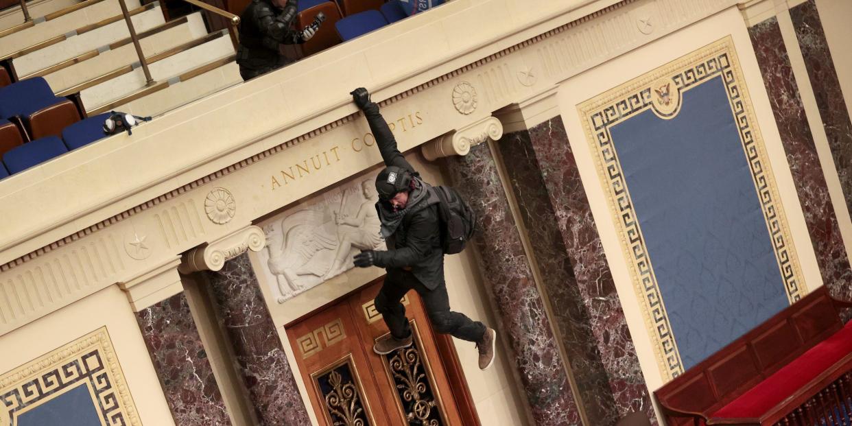 A protester is seen hanging from the balcony in the Senate Chamber on January 06, 2021 in Washington, DC. Congress held a joint session today to ratify President-elect Joe Biden's 306-232 Electoral College win over President Donald Trump. Pro-Trump protesters have entered the U.S. Capitol building after mass demonstrations in the nation's capital.