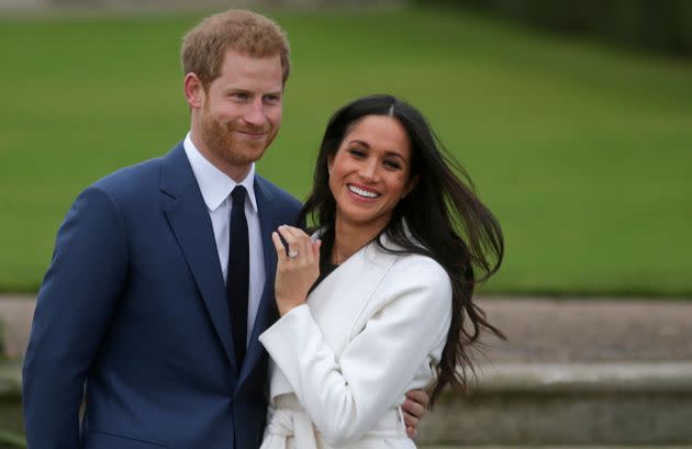 Prince Harry stands with his fiancée Meghan Markle as she shows off her engagement ring whilst they pose for a photograph in the Sunken Garden at Kensington Palace on Nov. 27, 2017. 