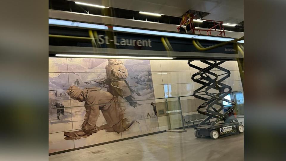 A worker at St-Laurent LRT station on May 17, 2024, looking into the ceiling tiles above the platform.