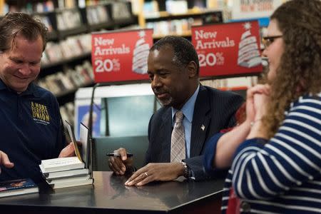 Republican presidential candidate Dr. Ben Carson signs copies of his book "A More Perfect Union" at a stop on his campaign and book tour in Ames, Iowa on October 24, 2015. REUTERS/Mark Kauzlarich