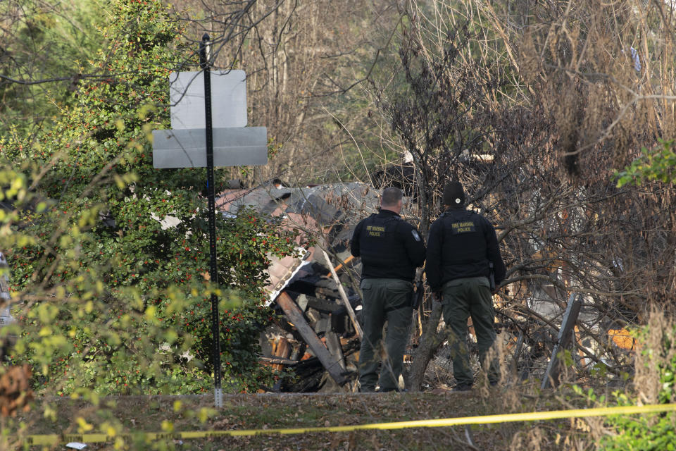 Members of the Arlington County Fire department looks towards the remains of a house explosion on Tuesday, Dec. 5, 2023, in Arlington, Va. (AP Photo/Kevin Wolf)