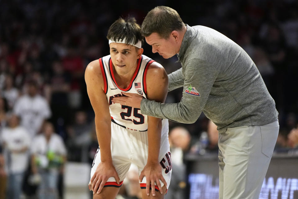 Arizona head coach Tommy Lloyd talks to guard Kerr Kriisa (25) during the first half of an NCAA college basketball game, Saturday, Feb. 4, 2023, in Tucson, Ariz. (AP Photo/Rick Scuteri)