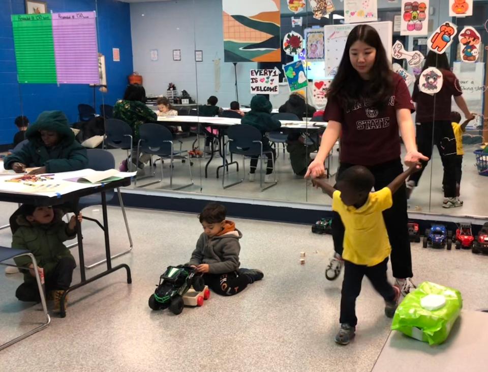 Missouri State University graduate student Taehee Park holds hands with Freddy, whose mom is taking English classes at the Boys and Girls Club of Springfield's Stalnaker Unit, on Wednesday, Nov. 29, 2023.