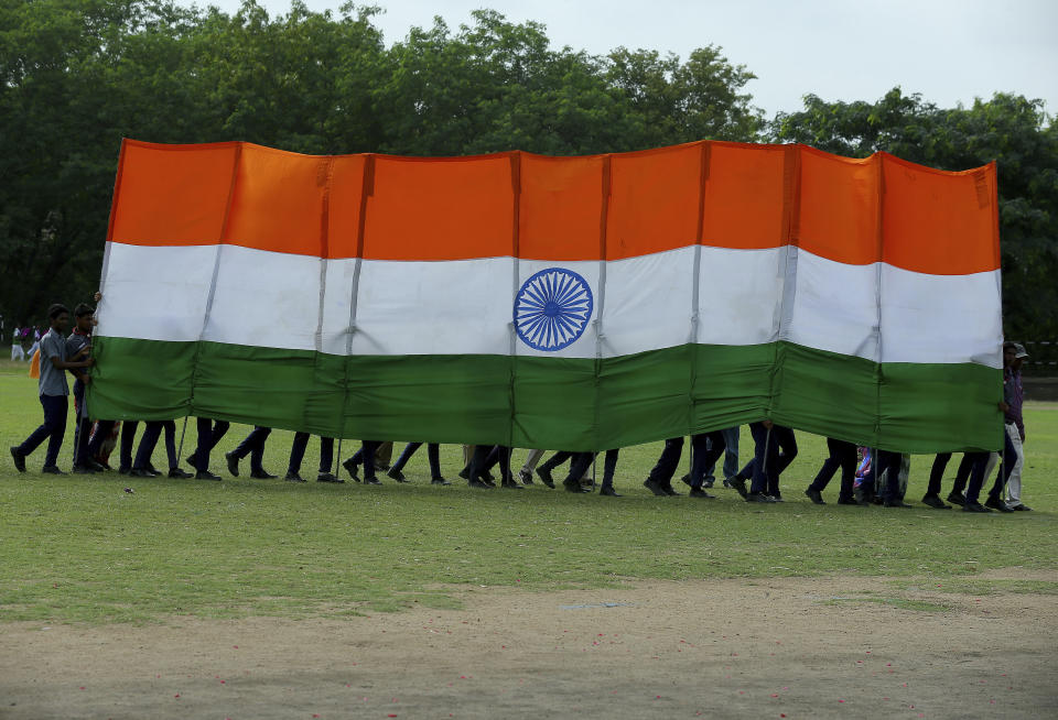 Students hold a huge Indian flag as they perform a dance during the Independence Day celebrations in Hyderabad, India, Thursday, Aug.15, 2019. Indian Prime Minister Narendra Modi defended his government's controversial measure to strip the disputed Kashmir region of its statehood and special constitutional provisions in an Independence Day speech Thursday, as about 4 million Kashmiris stayed indoors for the 11th day of an unprecedented security lockdown and communications blackout. (Mahesh Kumar A.)