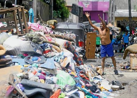 A man throws a briefcase that was caught in the floods in Wellampitiya, Sri Lanka May 25, 2016. REUTERS/Dinuka Liyanawatte