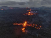 Eruptive fissures spew lava and smoke from a volcano in Grindavik, Iceland, Wednesday, May 29, 2024. A volcano in southwestern Iceland erupted Wednesday for the fifth time since December, spewing red lava that once again threatened the coastal town of Grindavik and led to the evacuation of the popular Blue Lagoon geothermal spa. (AP Photo/Marco di Marco)