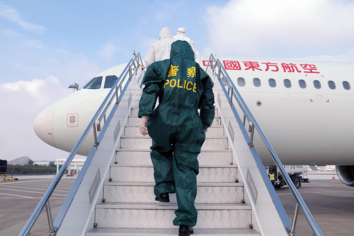 Chinese police officer and medical workers wearing protective clothing board a plane to check the body temperatures of the passengers onboard for prevention of the new coronavirus and pneumonia at Putuoshan Airport during the Chinese New Year or Spring Festival holiday in Zhoushan City, east China's Zhejiang Province on January 28th, 2020. (Photo by Zou Xunyong / Costfoto/Sipa USA)