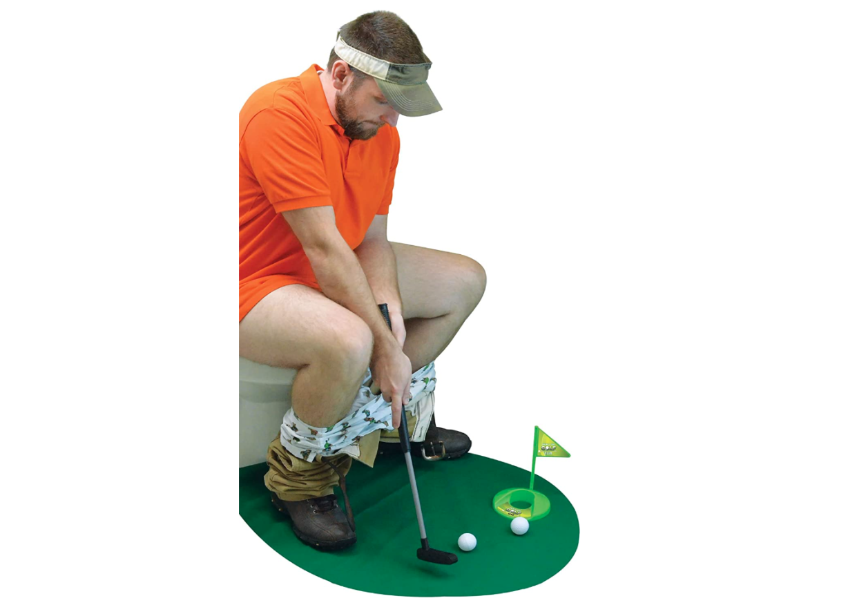 man playing putt putt golf sitting on toilet