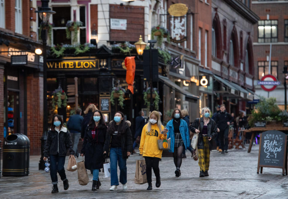 People wearing face masks in Covent Garden, in central London.