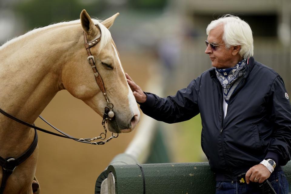 Trainer Bob Baffert pets an outrider's horse while watching workouts at Churchill Downs in April.