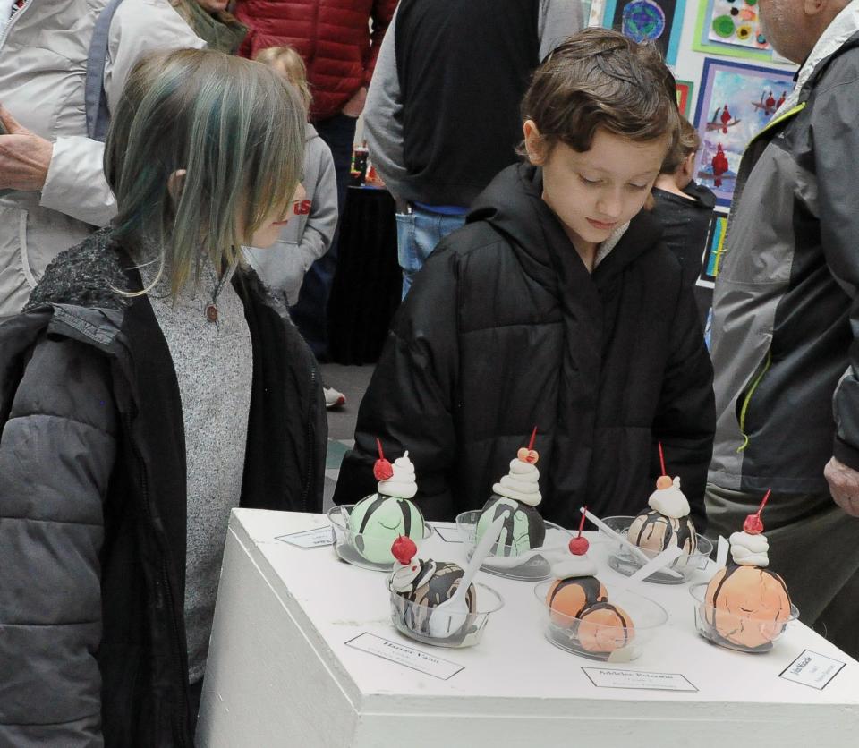 Ian Ledder and Merlin Blair look at a table of art ice cream sundaes at the Wooster City Schools 23rd annual Fine Arts Festival.
