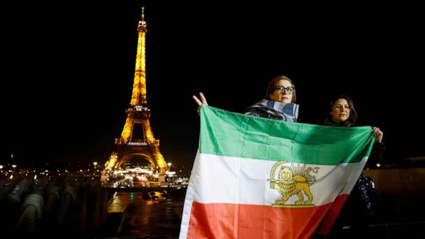 PHOTO: Protesters hold Iran's former flag on the Trocadero Esplanade Trocadero Esplanade during an event to display the slogan 'Woman. Life. Freedom.' on the Eiffel Tower, in a show of support to the Iranian people, in Paris, on Jan. 16, 2023. (Ludovic Marin/AFP via Getty Images)