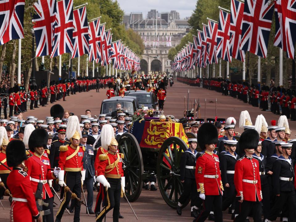 The Queen's funeral cortege borne on the State Gun Carriage of the Royal Navy travels along The Mall with the Gentlemen at Arms on September 19, 2022 in London, England.