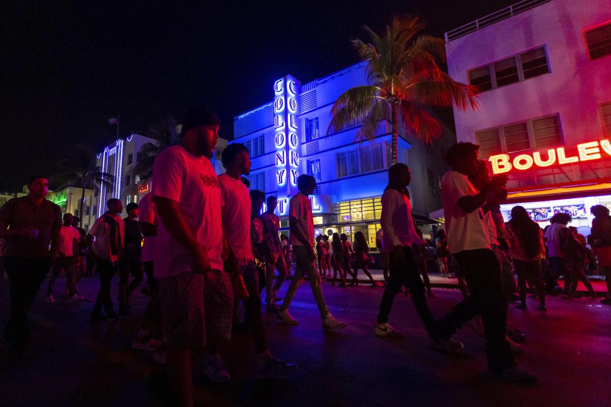 Crowds walk up and down Ocean Drive during spring break on Saturday, March 18, 2023, in Miami Beach, Fla. Miami Beach officials imposed a curfew beginning Sunday night, March 19, after two fatal shootings and rowdy, chaotic crowds that police have had difficulty controlling. (D.A. Varela/Miami Herald via AP)