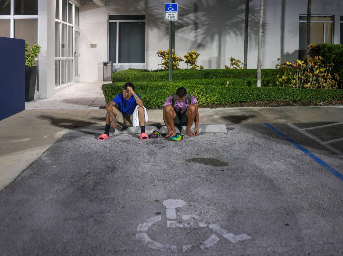 Franklin Pereira, 27, right, and Pedro Escalona were kicked out of their hotel rooms after losing their jobs with a hurricane cleanup company working in Fort Myers. In the parking lot with no money, they contemplate next steps.