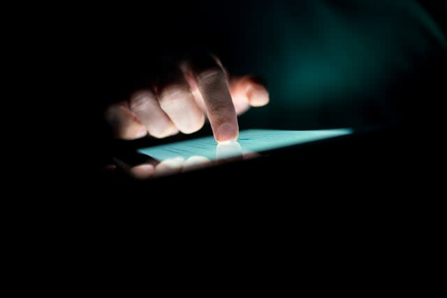 man using a tablet in the dark...