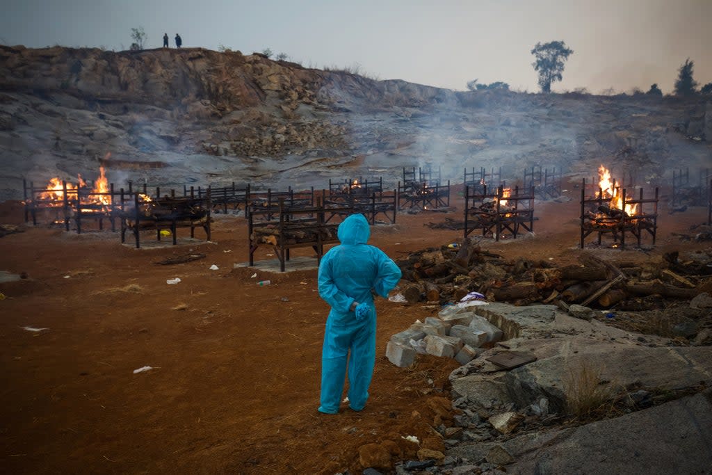 Archivo: Un hombre con PPE (Equipo de Protección Personal) observa cremaciones masivas durante la segunda ola de la pandemia de coronavirus el 30 de abril de 2021 en Bangalore, India (Getty Images)