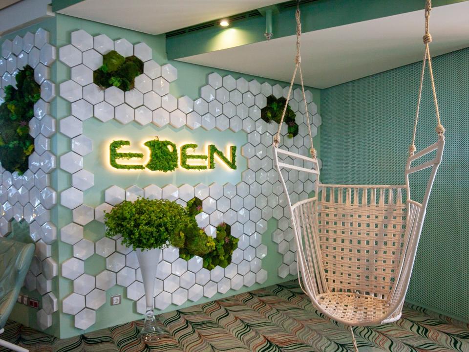 a hanging chair beside the Eden sign