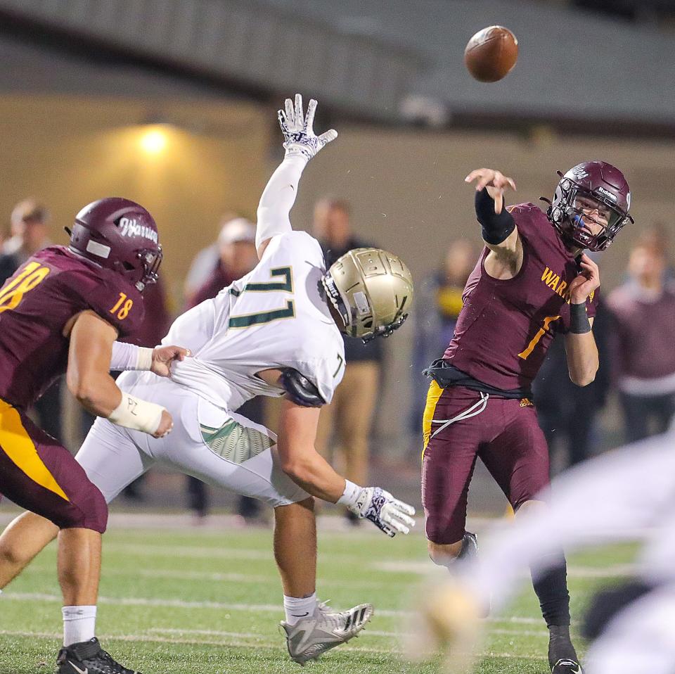 Walsh Jesuit quarterback Ryan Kerscher throws a pass while being pressured by St. Vincent-St. Mary's Bryson Getz, Friday, Oct. 21, 2022.