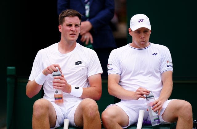 Henry Patten and his Finnish partner Harri Heliovaara talking while they sit down during the change of ends