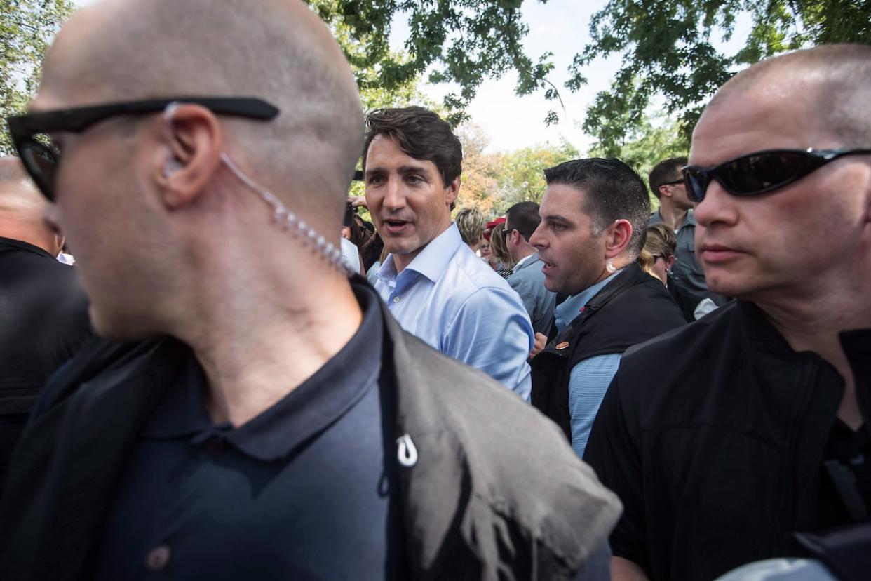 Prime Minister Justin Trudeau is surrounded by his security detail as he greets people in the crowd during a visit to B.C. Day celebrations in Penticton, B.C., on August 6, 2018. (Darryl Dyck/The Canadian Press - image credit)