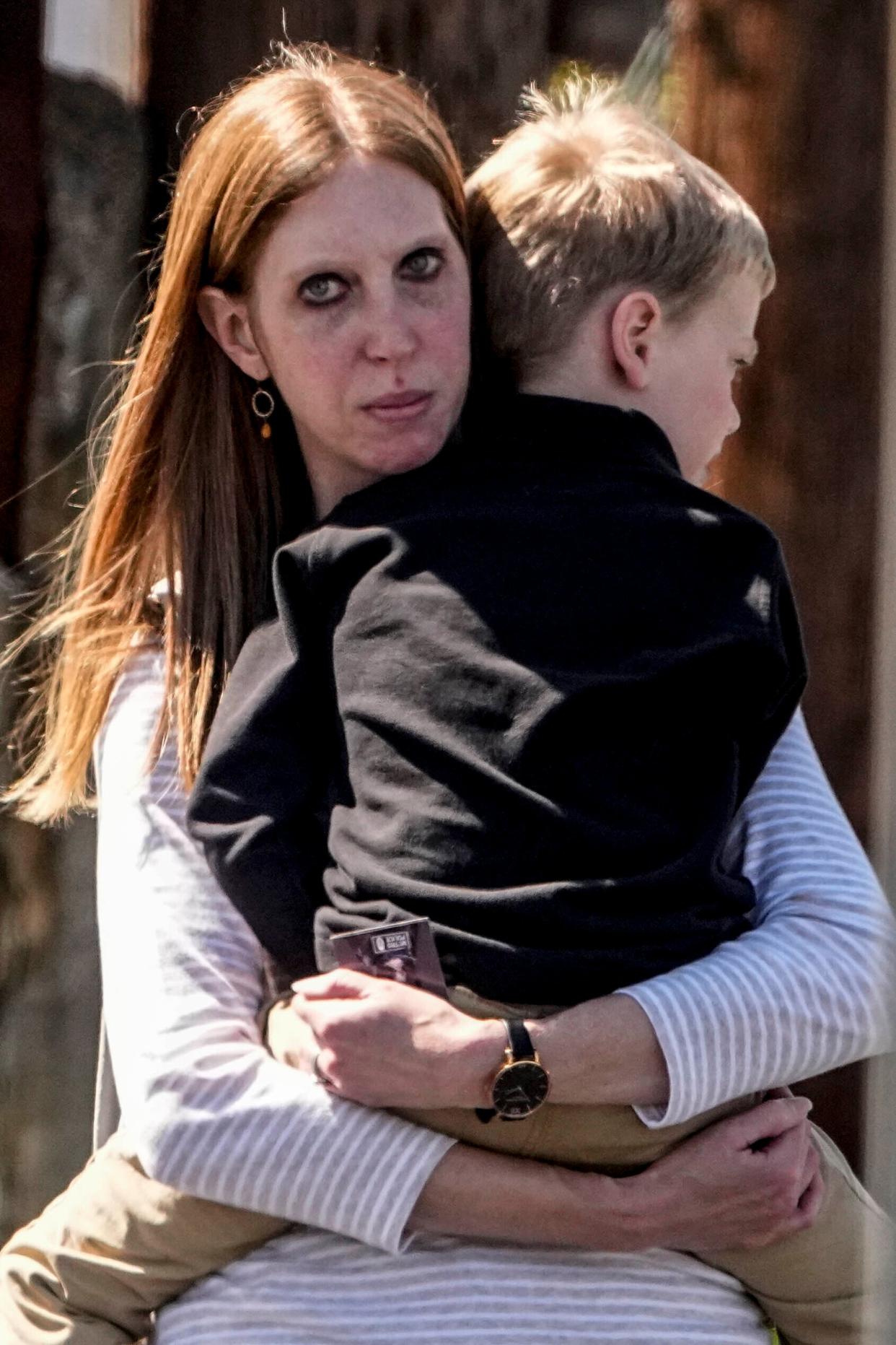 A woman carries a child out of the reunification center at the Woodmont Baptist church after a school shooting, Monday, March 27, 2023, in Nashville, Tenn. (AP)