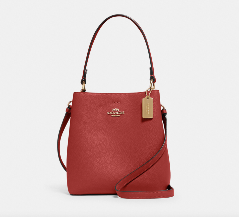 Small Town Bucket Bag in red leather with gold tag (Photo via Coach Outlet)