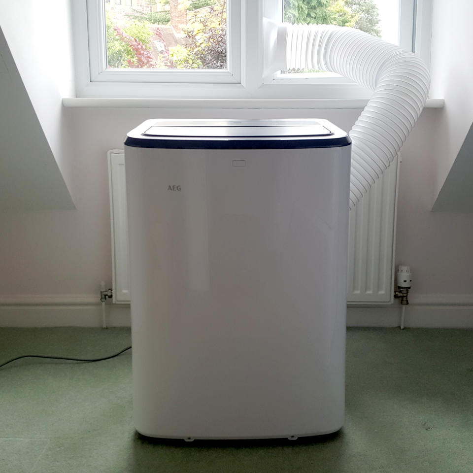 The AEG Comfort 6000 Portable Air Conditioner being tested in a room with green carpet