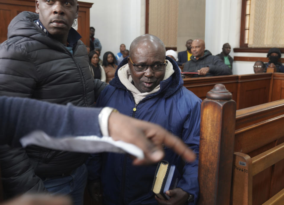 Fulgence Kayishema, center, enters the Magistrate's Court in Cape Town, South Africa, Friday, May 26, 2023. Kayishema is one of the most wanted suspects in Rwanda's genocide and is suspected of orchestrating the killing of some 2,000 people nearly three decades ago. (AP Photo/Nardus Engelbrecht)