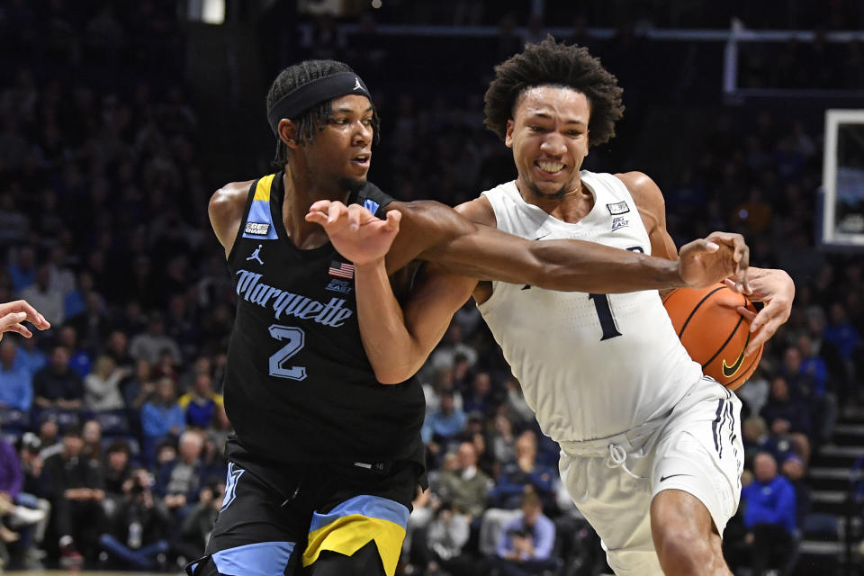 Marquette guard Chase Ross (2) attempts to get the ball away from Xavier guard Desmond Claude (1) during the first half of an NCAA college basketball game in Cincinnati, Saturday, March 9, 2024. Marquette won 86-80. (AP Photo/Timothy D. Easley)