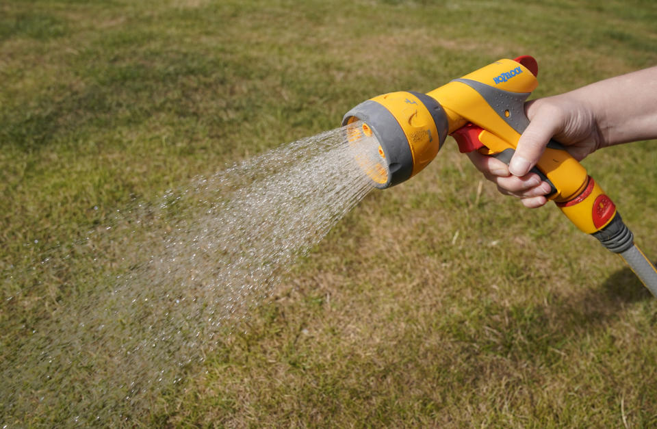 A person uses a hosepipe to water a lawn in Basingstoke, Hampshire. The first hosepipe ban of the year begins on Friday in Hampshire and the Isle of Wight. The moves to curb water use come after England has seen the driest eight-month period from November 2021 to July since 1976, when much of the country struggled in extreme drought. Picture date: Thursday August 4, 2022.