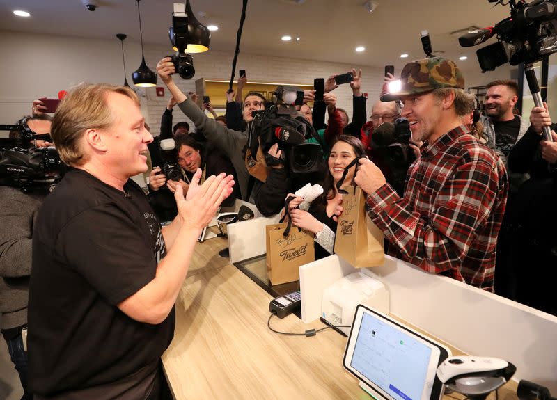 FILE PHOTO: Canopy Growth CEO Bruce Linton applauds after handing Ian Power and Nikki Rose, who were first in line to purchase the first legal recreational marijuana after midnight, their purchases at a Tweed retail store in St John's