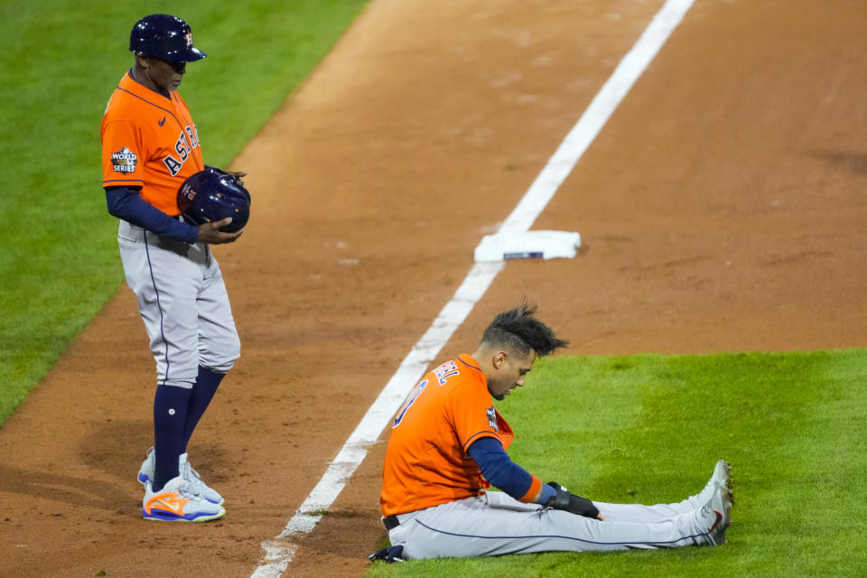 Houston Astros'  Yuli Gurriel, right, looks down after getting caught in a run down as third base coach Gary Pettis, left, comes by with his helmet during Game 5 of baseball's World Series against the Philadelphia Phillies, Thursday, Nov.  3, 2022, in Philadelphia.  (AP Photo/Chris Szagola)