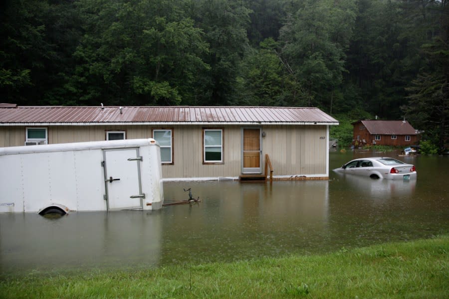 Floodwaters rise, July 10, 2023, in Bridgewater, Vt., submerging parked vehicles and threatening homes near the Ottauquechee River. Americans nationwide face hefty increases in their homeowner’s insurance premiums in the coming years, a report by the First Street Foundation said on Wednesday, Sept. 20, as climate change intensifies floods, wildfires and storms in ways insurance companies are simply unable to keep up with. (AP Photo/Hasan Jamali, File)