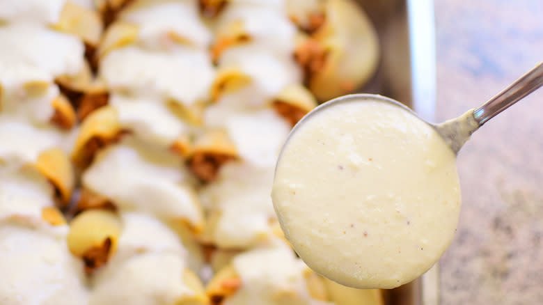 béchamel sauce ladled onto pasta