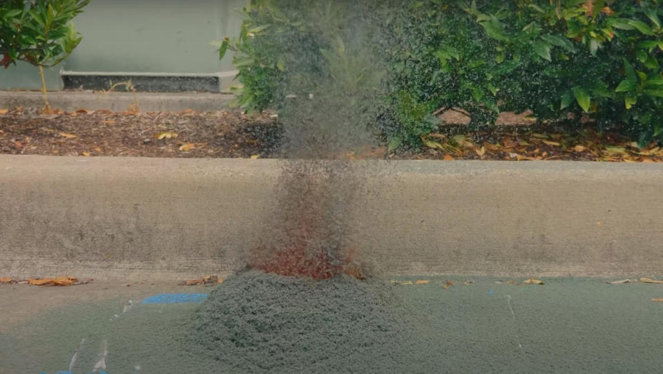 A giant mound of gray, decomposing ammonium dichromate blowing into the air.