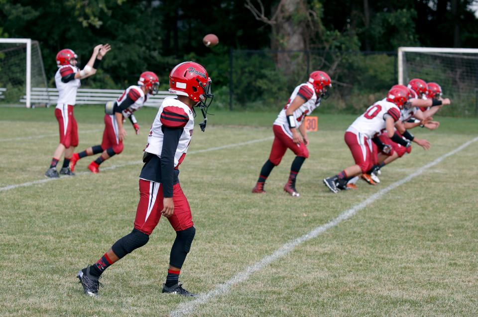 The Holley Hawks warm up before an 8-man football game in 2018 at The Charles Finney School.