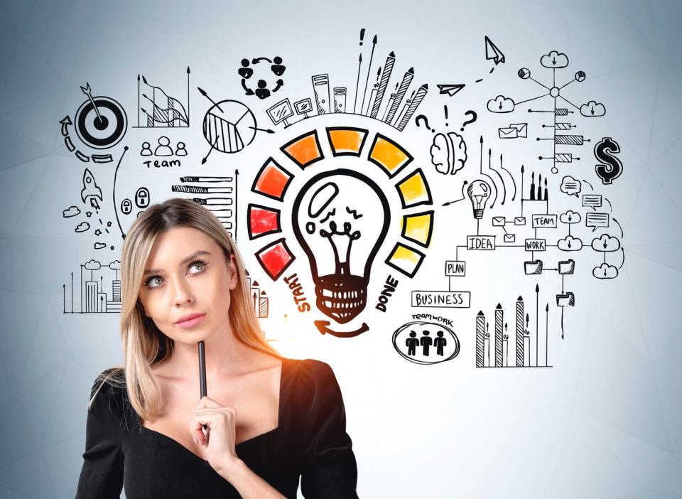 Person in front of drawings of light bulb and financial symbols, looking thoughtful.