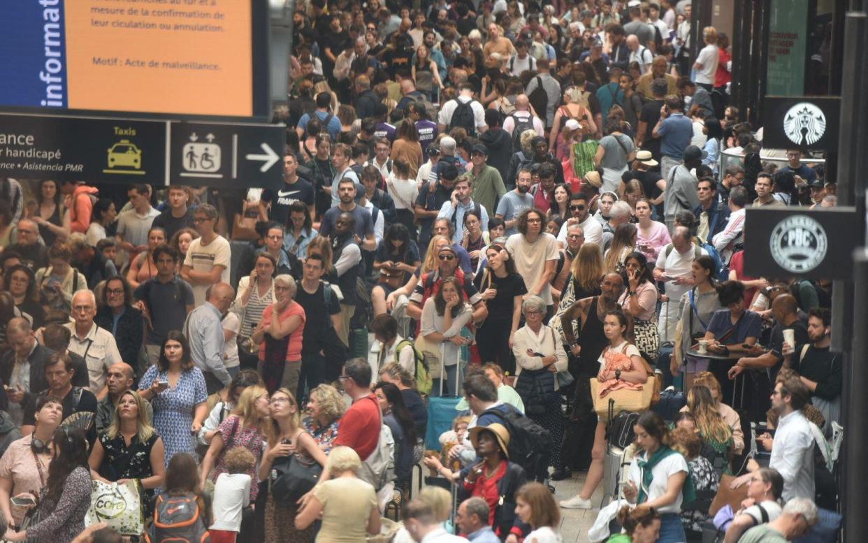 Passengers wait for their train departures at the Gare Montparnasse train station in Paris, France on July 26, 2024 as France's high-speed rail network was hit by malicious acts disrupting the transport system hours before the opening ceremony of the Paris 2024 Olympic Games.