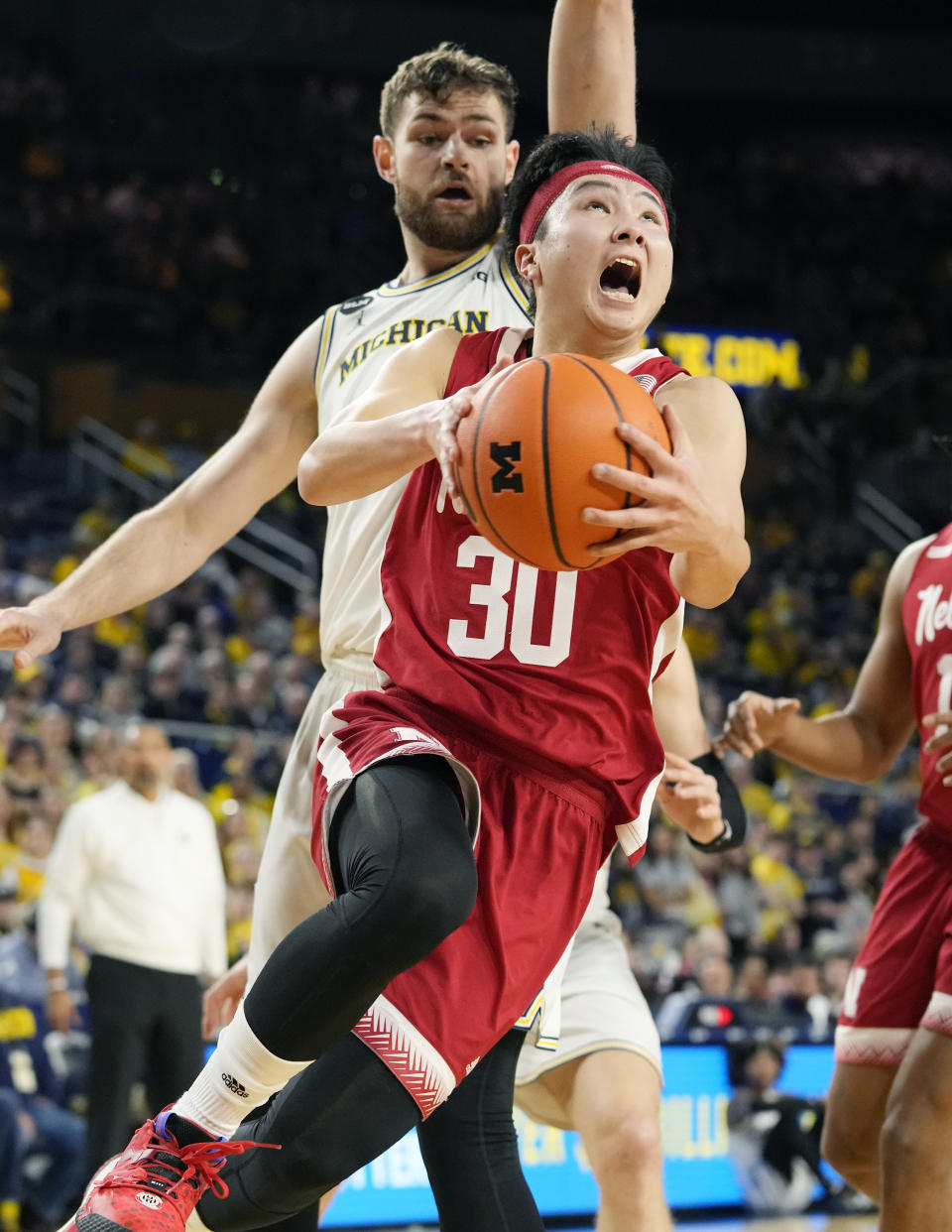 Nebraska guard Keisei Tominaga (30) makes a layup as Michigan center Hunter Dickinson (1) defends during the first half of an NCAA college basketball game, Wednesday, Feb. 8, 2023, in Ann Arbor, Mich. (AP Photo/Carlos Osorio)