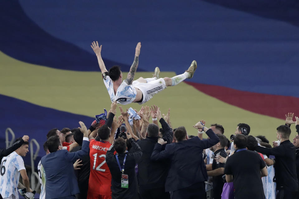 Argentina's team throw Lionel Messi up in the air as they celebrate after beating 1-0 Brazil in the Copa America final soccer match at the Maracana stadium in Rio de Janeiro, Brazil, Saturday, July 10, 2021. (AP Photo/Andre Penner)