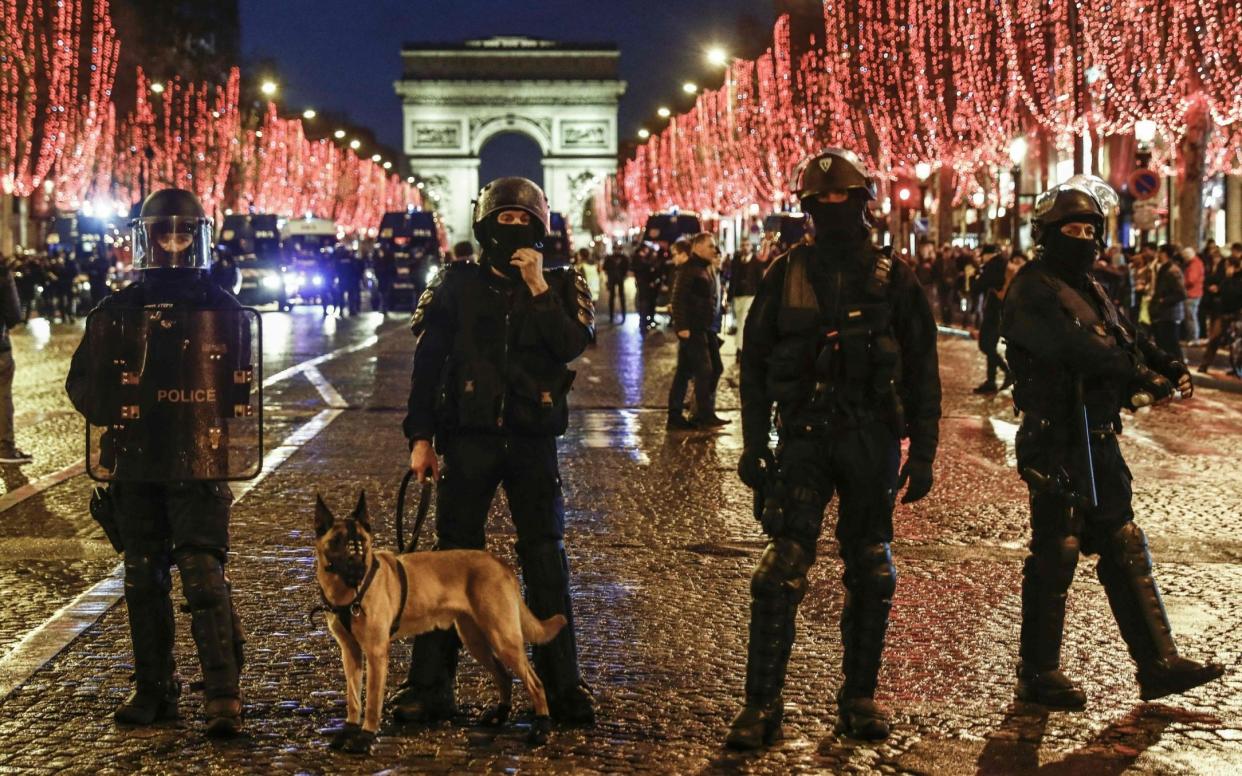 Police forces stand on the Champs Elysees avenue after they dispersed some demonstrators of the French "yellow vests" - AFP