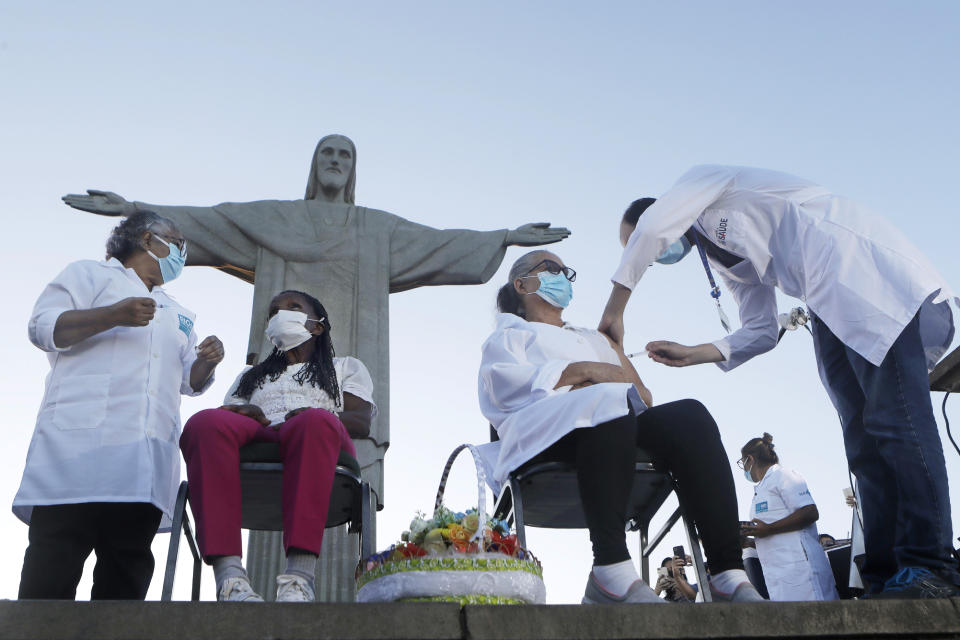 FILE - In this Monday, Jan. 18, 2021, file photo, Terezinha da Conceicao, 80, left, and Dulcinea da Silva Lopes, 59, become the first women in the country to receive the COVID-19 vaccine produced by China's Sinovac Biotech Ltd, during the start of the vaccination program in front of the Christ the Redeemer statue in Rio de Janeiro, Brazil. China’s vaccine diplomacy campaign has pledged roughly half a billion doses of its vaccines to dozens of countries. (AP Photo/Bruna Prado, File)