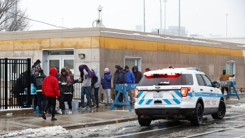 Migrants get food Friday outside Chicago's migrant landing zone. - Kamil Krzaczynski/AFP via Getty Images