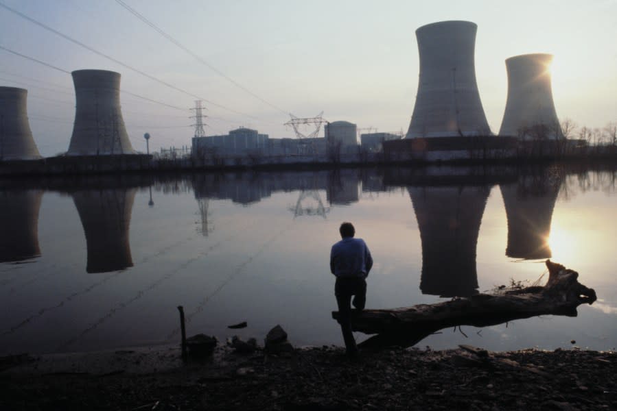 (Original Caption) The sun sets behind the Three Mile Island nuclear power plant. The crippled reactor, the round building on the left of the cooling towers, is cooling down.