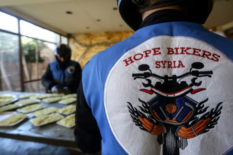 Des membres du club de motards "Hope Bikers Syria" préparent la distribution de repas aux personnes dans le besoin pendant le ramadan, le 25 mars 2024 à Damas, en Syrie (LOUAI BESHARA)